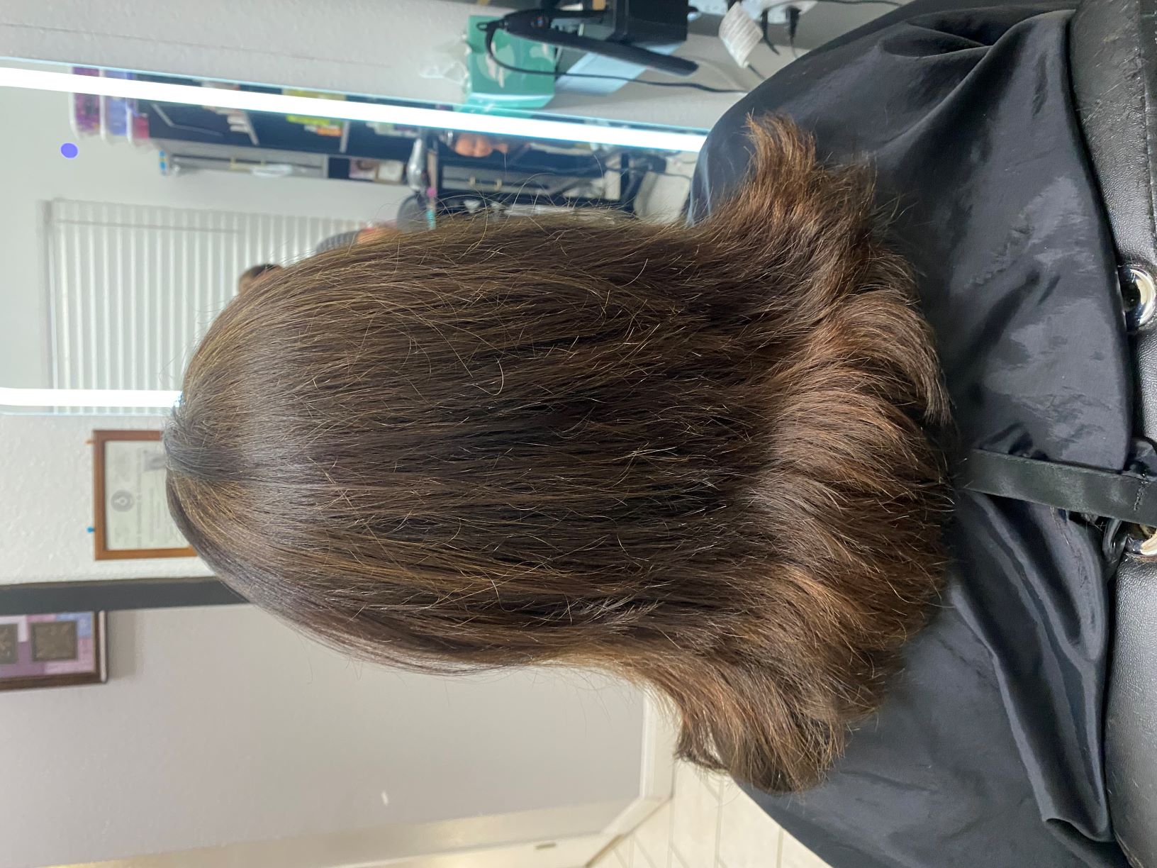 Woman with layered brown hair in salon chair