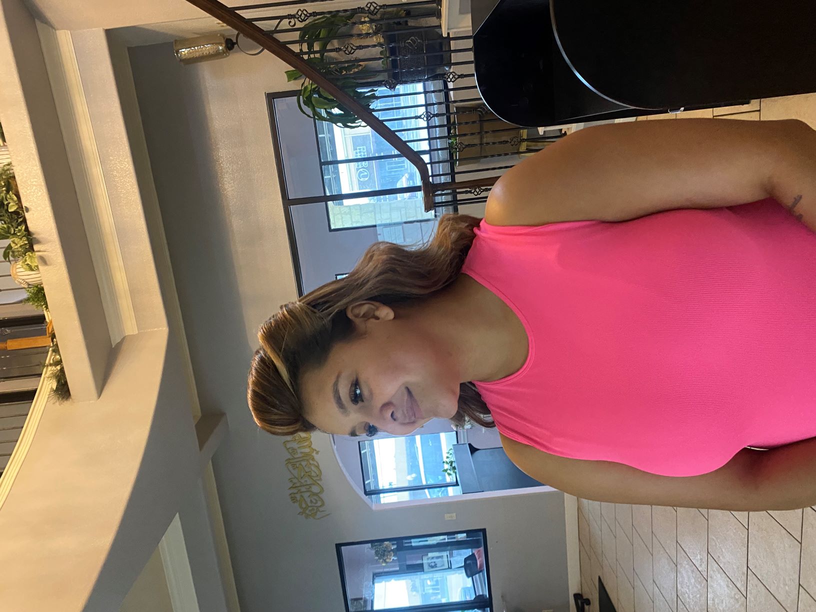 Woman in a bright pink dress inside a modern interior