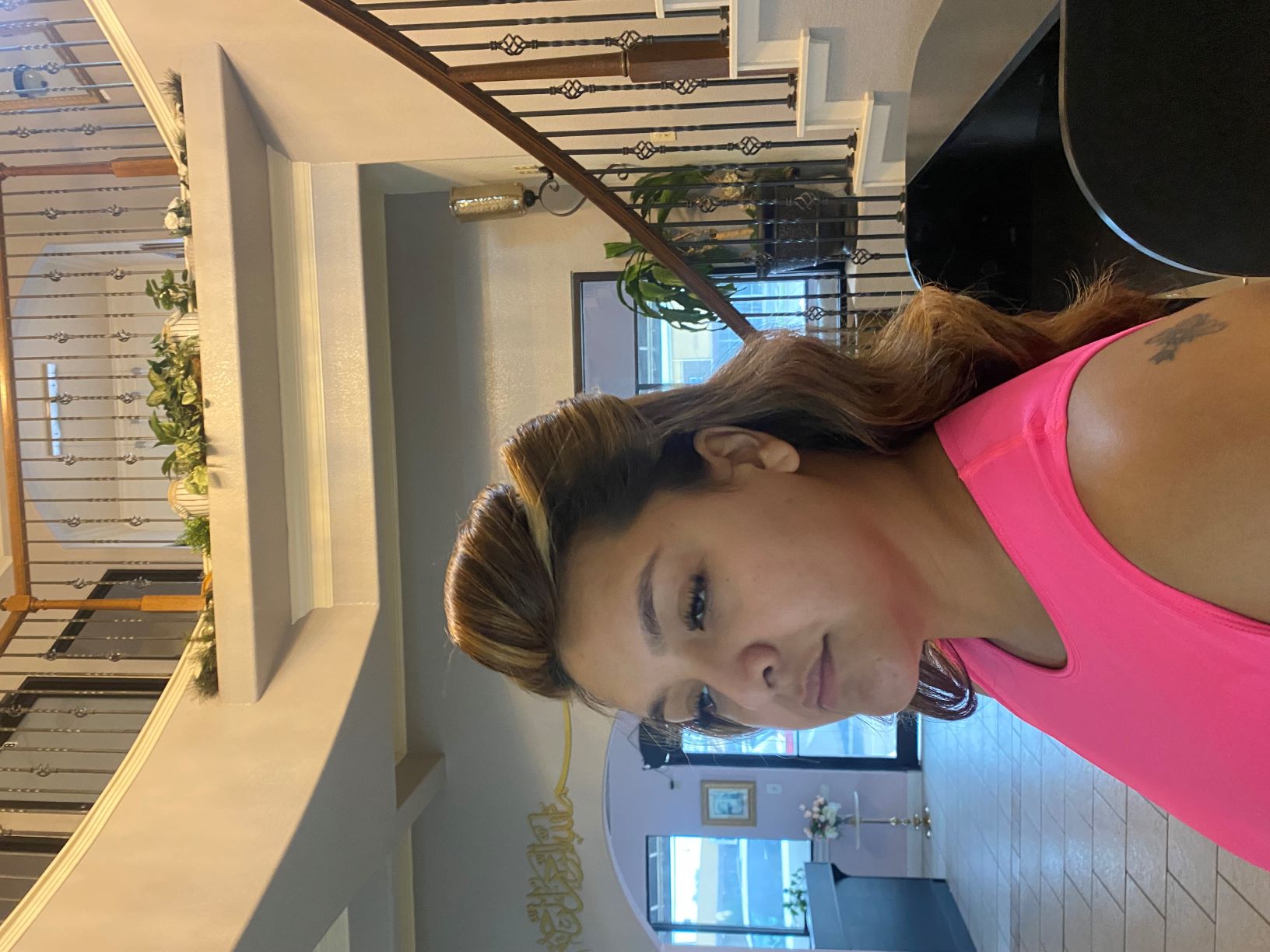 Woman with styled hair in a pink top in a modern interior